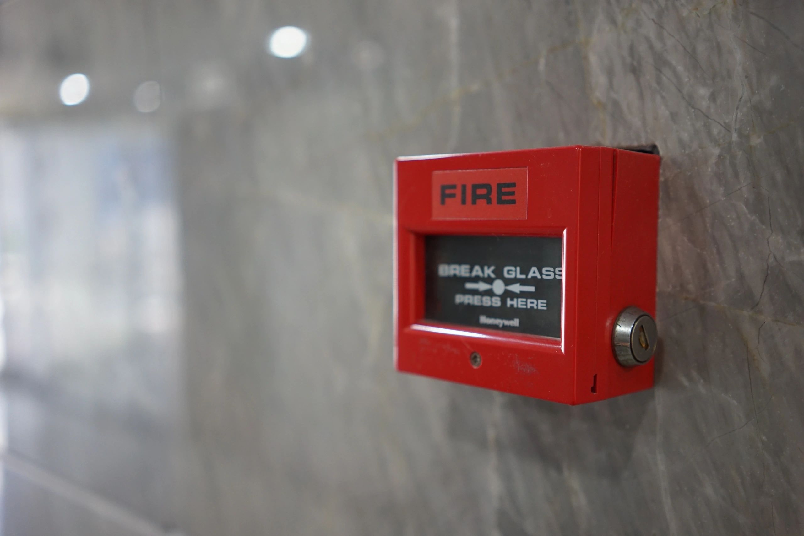Fire alarm break glass call point on concrete wall